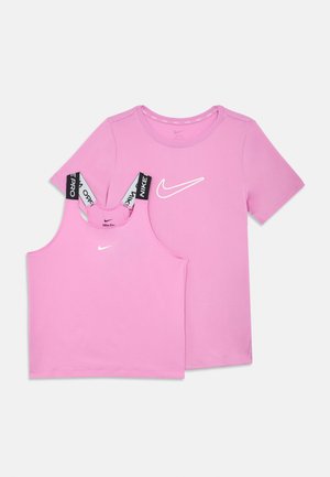 Rozā Nike īsām piedurknēm T-krekls un atbilstošs topiņš ar melniem Nike Pro zīmola siksniņām, abi ar baltām Nike swoosh logo.