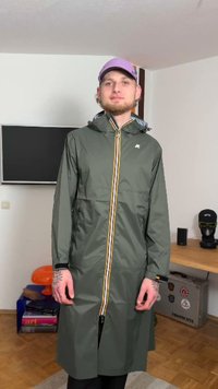 Žalia vandeniui atspari striukė su gaubtu, priekyje užsegama užtrauktuku ir geltonomis bei baltomis juostelėmis. Turi kišenes ir ilgą, laisvo kirpimo siluetą.