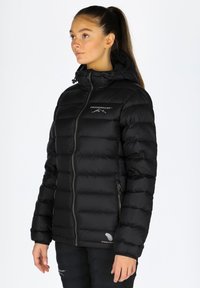 Czarna kurtka puchowa z zapięciem na zamek, kapturem i przeszytymi panelami. Posiada logo na klatce piersiowej oraz logo piór na dolnym brzeg.