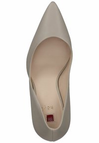 Décolleté beige in pelle a punta con una superficie liscia e lati intagliati, caratterizzata da un piccolo quadrato rosso sull'interno della soletta.