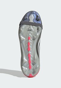 Suela de zapato deportivo negro con superficie gris, con acentos rosas, tacos multidireccionales y un diseño texturizado para tracción.