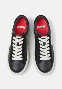 Black leather sneakers with white laces, white soles, and red insoles branded "Camper" viewed from above on a white background.