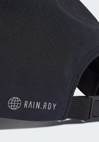 Gorra negra con un tejido suave y texturizado. Presenta un logo blanco "RAIN.RDY" y una correa ajustable con un cierre de clip.