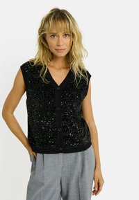 Gilet sans manches noir en tissu pailleté avec un col en V, doté d'une fermeture à boutons sur le devant et d'un ourlet côtelé.