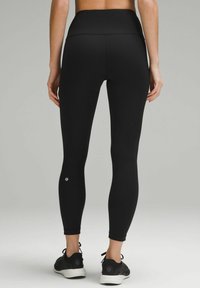 Czarne legginsy z wysokim stanem, o prążkowanej teksturze, w pełnej długości, z małym logo marki na dolnej części nogawki. Można je zestawić z czarnymi butami sportowymi.