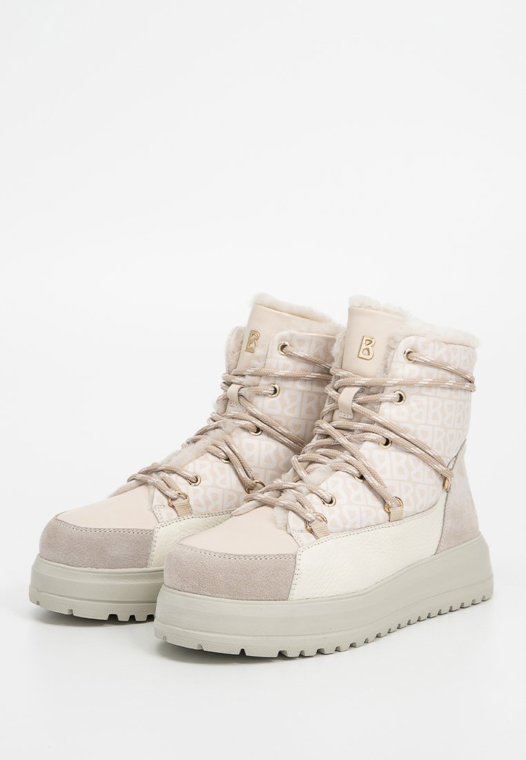 Beżowe botki za kostkę z teksturowanym wzorem, z podszyciem z sztucznego futra, metalowymi oczkami i grubą gumową podeszwą dla lepszej przyczepności.