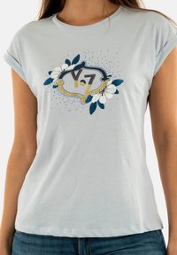T-shirt azzurro chiaro con maniche corte, caratterizzato da una grafica luccicante con "Y7" in nero e oro, circondato da accenti floreali e punti.
