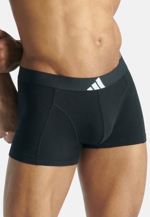 Boxer shorts noirs avec une ceinture confortable présentant trois bandes blanches. Fabriqués en tissu doux et extensible avec des coutures plates.