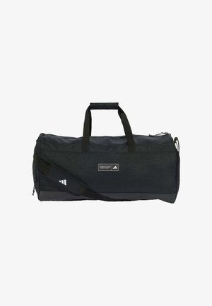 Czarna torba sportowa Adidas z dwoma uchwytami, paskiem na ramię, zamkiem błyskawicznym i małą naszywką z logo z przodu.