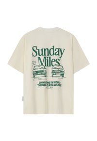 Bézs póló zöld felirattal: "Sunday Miles" és két klasszikus autó vázlataival, méretekkel és a "Connecting the world through classic culture." jelmondattal.