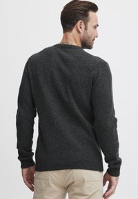 Pulover din lână de culoare gri închis, cu mâneci lungi, guler rotund, finisaj texturat și manșete și tiv cu nervuri, prezentat din spate.