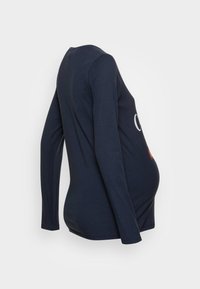 Tengerészkék, hosszú ujjú kismama póló, lekerekített nyakkivágással, rugalmas anyaggal, és hangsúlyos logóval az elején, a kényelem érdekében tervezve.