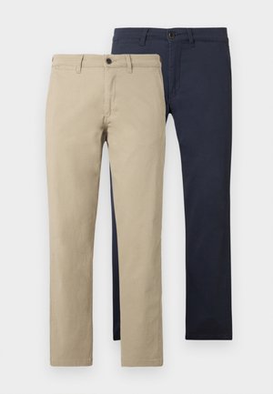 Khaki en marineblauwe chinos naast elkaar weergegeven. Beide hebben een rechte pijp, een effen voorkant en een sluiting met één knoop. Katoenen stoffen textuur.