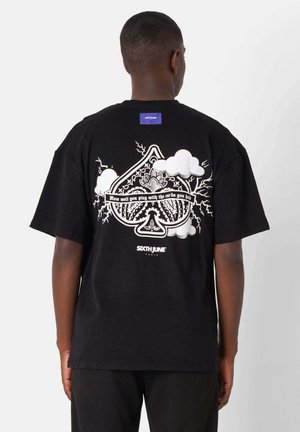 Schwarzes Baumwoll-T-Shirt mit einem großen Grafikdruck auf dem Rücken, der weiße Designelemente, darunter Wolken und stilisierte Schriftzüge, sowie ein blauer Aufnäher zeigt.