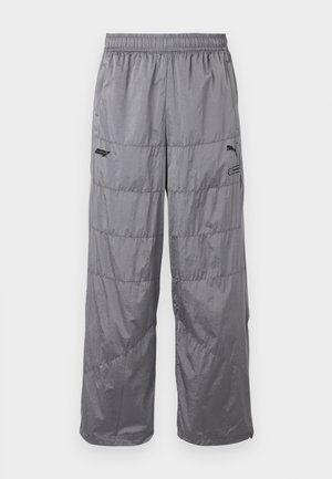 Grå pufferbukser med elastisk talje, prydet med kviltede designlinjer og et lille sort logo på venstre lår. Letvægtsmateriale.