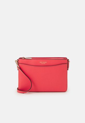 Rødt læder håndledsclutch med gyldent lynlås og "kate spade new york" logo præg på frontlommen.