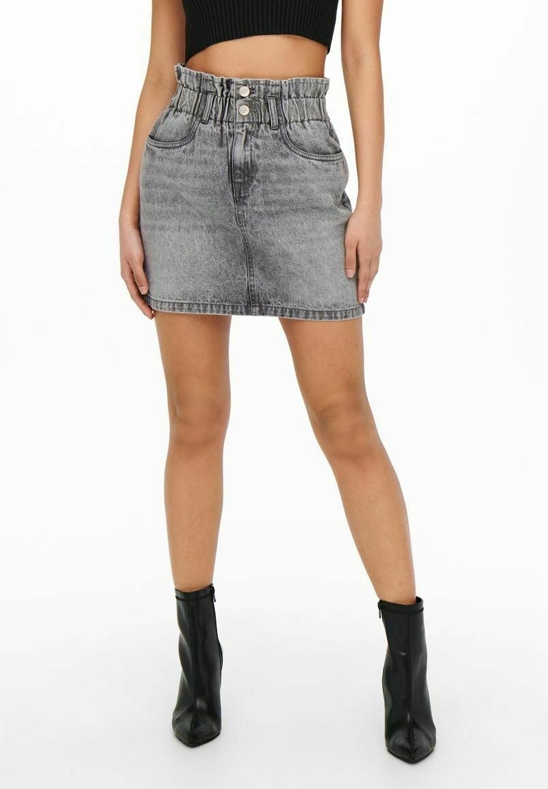 Grauer Denim-Minirock mit gerafftem Bund, zwei vorderen Taschen und Knopfverschluss; kombiniert mit schwarzen Stiefeletten.