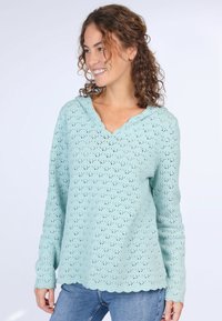 Helle blaue, gehäkelte Strickjacke mit gewelltem Saum und V-Ausschnitt, langen Ärmeln und lockerer Passform. Das Muster weist kleine Durchbruchdetails auf.