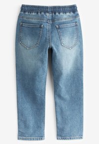 Sinine denim-püksid, millel on elastne vöökoht, kaks tagumist taskut, millel on õmmeldud detailid, ja kitsenev sääredisain.