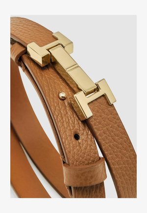 Tanový kožený pásek s texturovaným povrchem, vybavený zlatým kovovým přezkou ve tvaru geometrického vzoru. Nastavitelný díky více dírkám.