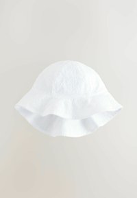 Witte katoenen bucket hat met een geperforeerd patroon, ronde kroon en brede, golvende rand. Glad lichaamsvoering.