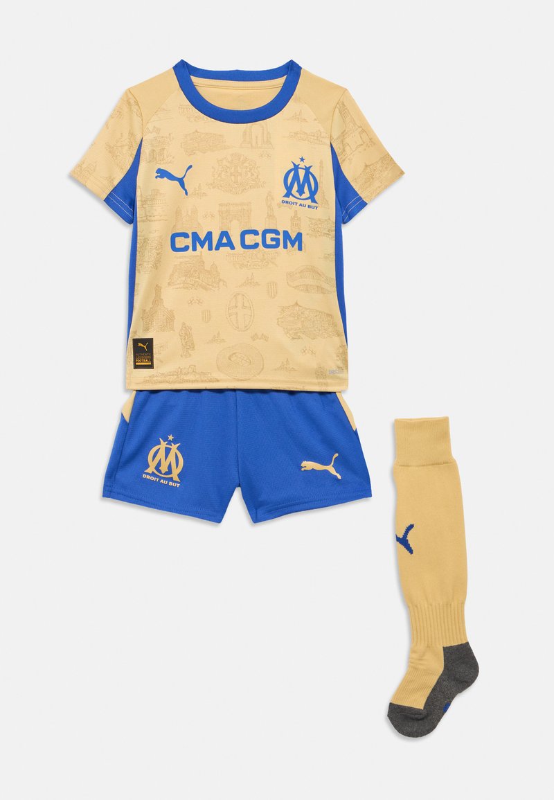 Futbalový dres zahŕňa žltý dres s modrými akcentmi a vzorom, modré šortky a žlté ponožky so sivými detailmi a logom.