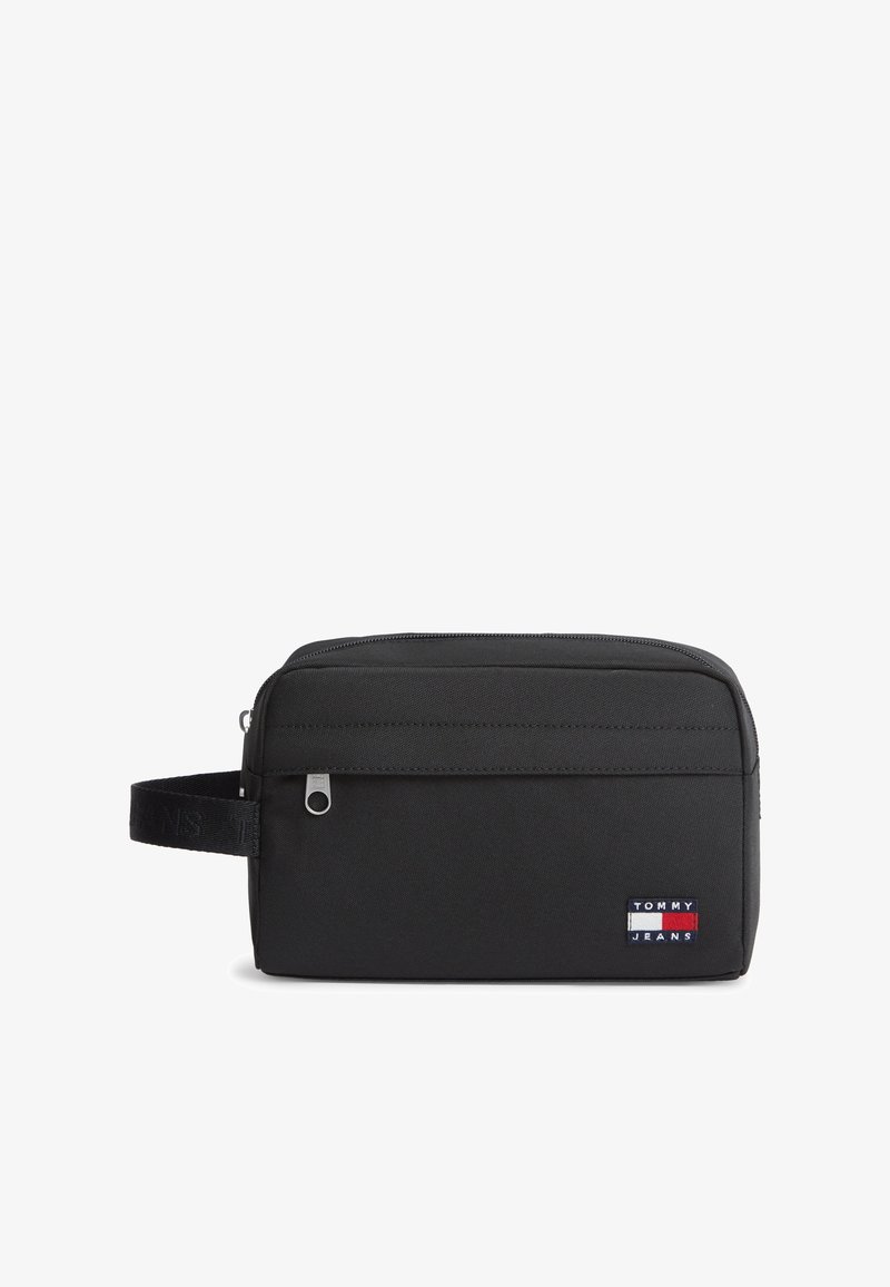 Μαύρο ορθογώνιο νεσεσέρ με μπροστινή τσέπη με φερμουάρ, πλευρική λαβή και το μπάλωμα με το λογότυπο Tommy Jeans στη μπροστινή κάτω δεξιά γωνία.