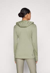 Sweatshirt de mangas longas, com capuz, em tecido verde-oliva claro, apresentando uma textura suave e capuz correspondente, com um corte descontraído.