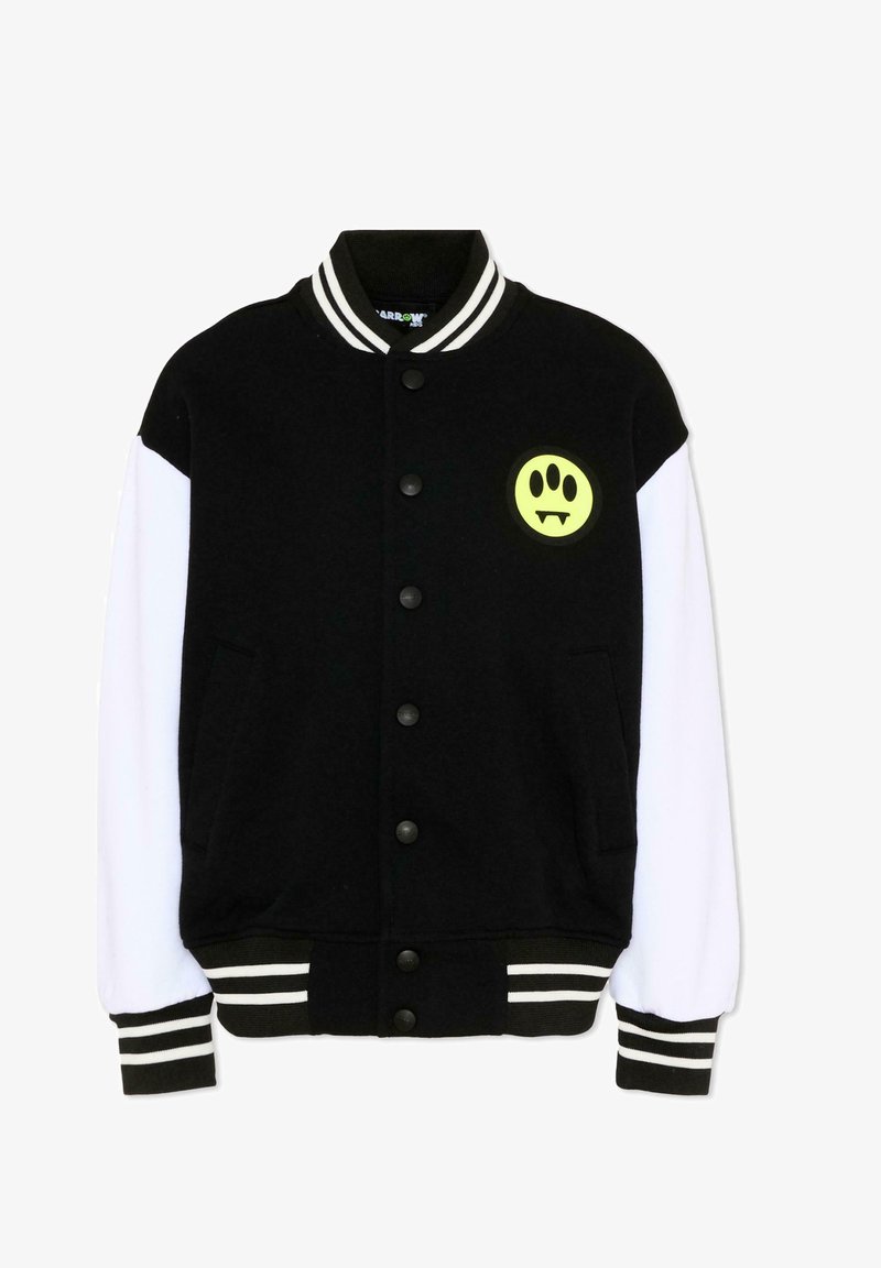Veste universitaire noir et blanc avec boutons pression, col et poignets rayés, et un patch visage souriant jaune avec des crocs sur la poitrine.