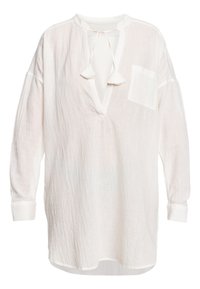 Camicia bianca in lino, dal taglio ampio e comodo, con scollo a V, chiusura con lacci, maniche lunghe e taschino sul petto. Tessuto testurizzato con un design rilassato.