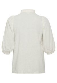 Blouse en lin blanc avec un col au dos, des manches bouffantes et une coupe décontractée. Texture douce et finition lisse, idéale pour des tenues décontractées.
