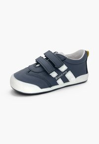 Basket pour enfant bleu marine avec deux bandes Velcro, rayures blanches, bout et semelle en caoutchouc, et languette jaune au talon. Marque Blanditos.