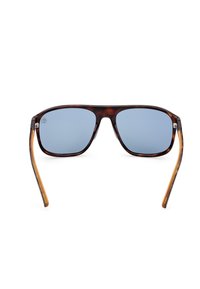 Occhiali da sole tartaruga con lenti blu, montatura quadrata e aste eleganti in marrone con un delicato gradiente. Hardware metallico visibile ai lati.