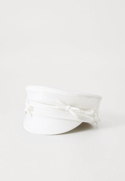 Gorra blanca con un diseño estructurado, que presenta un visor plano y lazos decorativos en la parte delantera para un detalle refinado. Material suave.