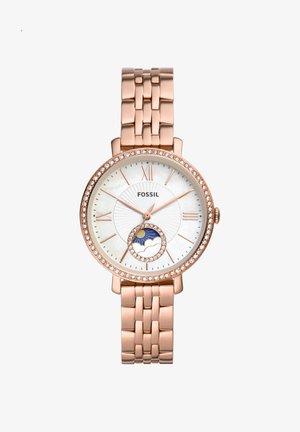 Montre-bracelet Fossil en or rose avec lunette ornée de cristaux, cadran blanc, chiffres romains et sous-cadran jour-nuit avec soleil et nuage à 6 heures.