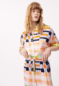 Multicolore overhemd met korte mouwen, met een ruitpatroon in roze, oranje, zwart en groen. Elastische tailleband met trekkoord.