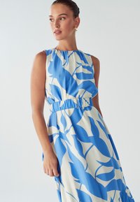 Sukienka bez rękawów z niebiesko-białym abstrakcyjnym wzorem liści, z marszczonym dekoltem i elastycznymi talią ozdobioną srebrną klamrą.
