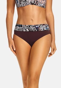 Spodenki kąpielowe w ciemnym brązie z wielokolorowym nadrukiem w pasie, przedstawiającym wzory zwierzęce i geometryczne. Gładki materiał, średni wzrost.