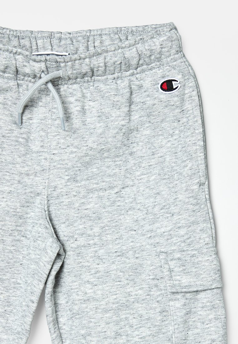 Pantaloni della tuta grigi realizzati in un tessuto morbido e testurizzato. Presentano un elastico in vita con coulisse e un piccolo logo in alto a destra.