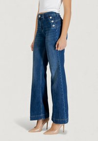 Jeans blu a vita alta con gambe larghe in denim, caratterizzati da quattro bottoni argentati sulla cintura e un orlo pulito.