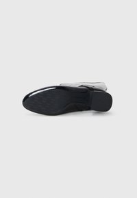 Botim preto até ao tornozelo com acabamento brilhante, sola texturizada e um design suave. Inclui biqueira arredondada e fecho lateral para fácil acesso.