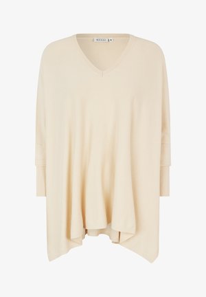 Beżowa, luźna bluzka z dekoltem w serek, trzema ćwiartkami rękawów i żebrowanymi mankietami. Miękka, gładka tekstura z delikatnie zaokrąglonym dołem.