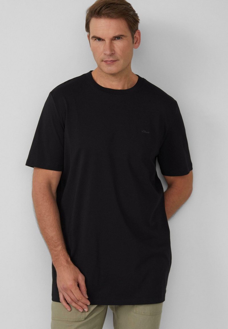 Zwarte katoenen t-shirt met een ronde halslijn en korte mouwen, met een klein logo-accent op de borst en een ontspannen pasvorm.