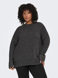 Oversized gray knitted sweater with ribbed hems and studded accents on cuffs. Soft texture, round neckline, and long sleeves.