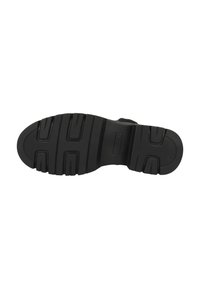 Suola di scarpa in gomma nera con un motivo testurizzato, dotata di scanalature profonde per migliorare la trazione e un design piatto con punta arrotondata.