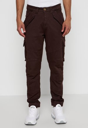 Brown cargo pants with multiple side pockets, a button closure, and a tapered fit, made of durable fabric with a matte finish.