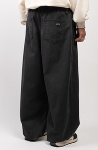Pantaloni ampi neri in denim con vita elastica, dotati di due tasche posteriori e di un piccolo etichetta con il marchio vicino alla vita.