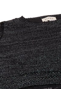 Top nero in tessuto intrecciato con fili metallici, scollatura rotonda, tessuto texturizzato e un'accento in pizzo all'orlo. Etichetta visibile: ZITHA.