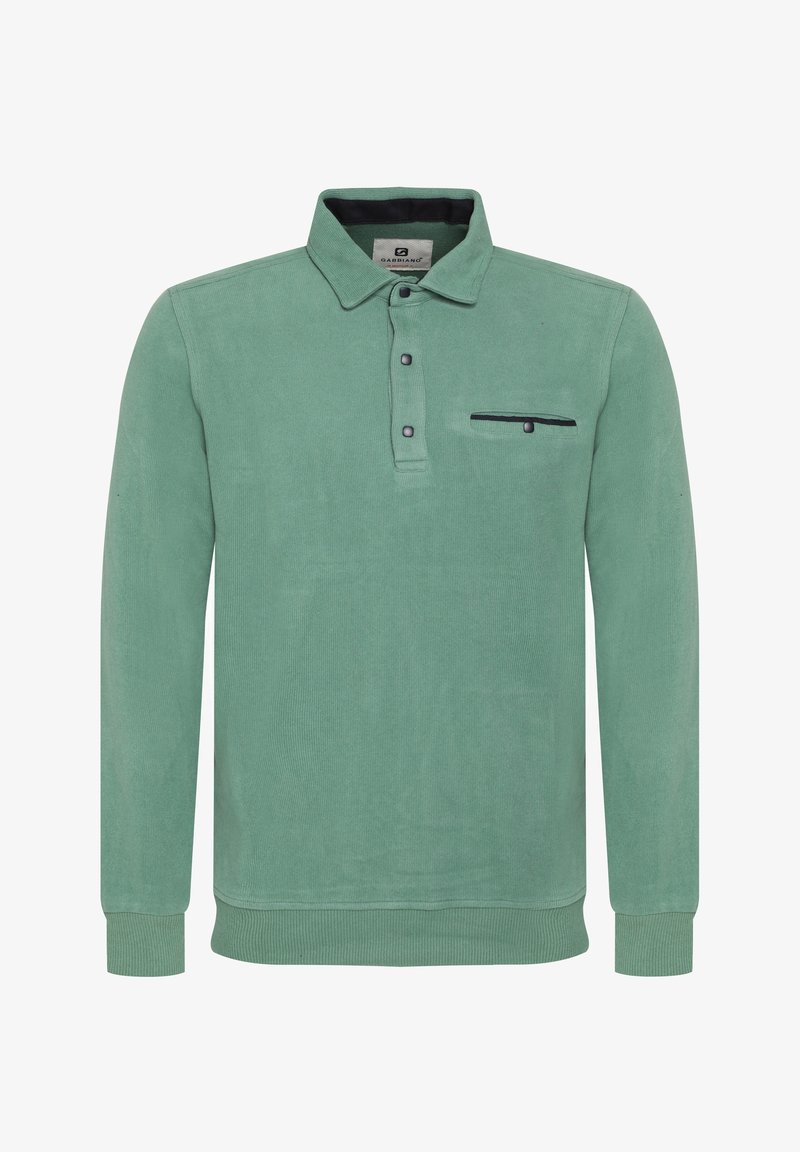 Vihreä puuvillainen pitkähihainen polo, jossa on kauluspaita, kolmesta nappista koostuva napitus ja rintatasku, jossa on musta yksityiskohta.