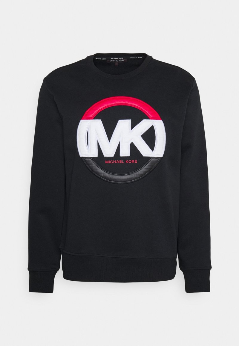 Sweatshirt noir à col rond avec grand logo MK blanc, détail cercle rouge et noir, et petit texte rouge "Michael Kors" centré sous le logo.